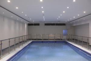 a large swimming pool in a building with a balcony at Burj Alhayah Hotel Suites Alfalah in Riyadh