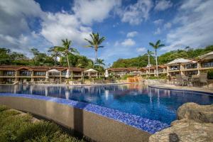 a swimming pool at a resort with palm trees at Palms 5 Luxury Beachfront Villa in Playa Flamingo