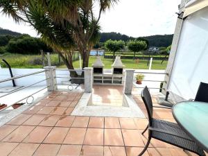 a patio with chairs and a table and a view of the water at Naturmar in Raxó
