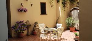 a patio with a table and chairs and flowers at Villa Pina in Vico Equense