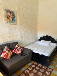 a bed and a couch in a room at Casa Orquidea Hostal Barichara in Barichara +12 photos