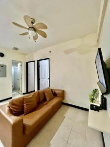 a brown couch in a living room with a ceiling fan at 2BR Kelsey Haven With Balcony in Davao City