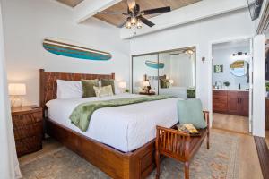 a bedroom with a large bed and a mirror at Ocean-front penthouse, sunsets, whales, surfers! Newly remodeled! in Kailua-Kona +27 photos