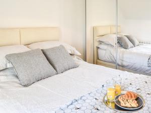 a bed with a tray of food on it at Sheep's View Cottage in Eastbourne