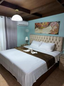 a bedroom with a large bed with white sheets at El Cayuco Restaurant Apart Hotel in Boca Chica