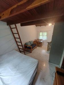 an attic room with a bed and a table at Flat Maresias in São Sebastião