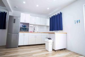 a kitchen with white cabinets and a refrigerator at Casa Rosado Rincon Rayo Suite Mountain View Pool in Rincon