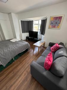 un salon avec un canapé et un lit dans l'établissement Renfrew Road, à Hounslow