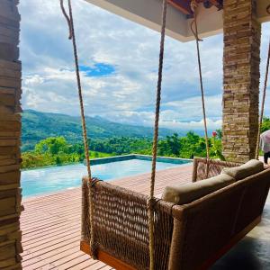 a porch swing with a view of a swimming pool at Fundo Shanti in Lamas +24 photos