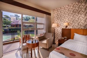 a hotel room with a bed and a chair and a window at Griya Persada Convention Hotel & Resort Bandungan in Bandungan +47 photos
