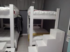 two white bunk beds in a small room at CBD City views on 61 wale street by M&B in Cape Town +22 photos