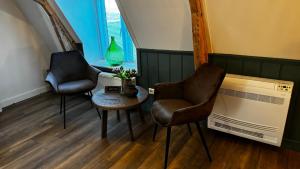 two chairs and a table in a room with a window at De Zaandbarg in Nijeveen