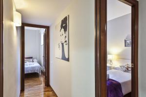 a room with two beds and a mirror at Sarria Attic in Barcelona