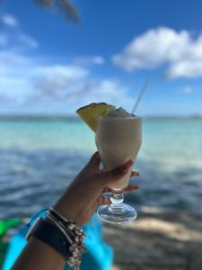 a person holding up a drink with a lime at El Cayuco Restaurant Apart Hotel in Boca Chica