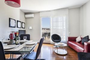 een woonkamer met een tafel en een rode bank bij Sarria Attic in Barcelona