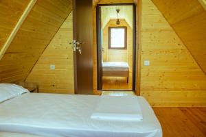 a bedroom with a bed and a bathroom with a mirror at Cozy Cottages Kondidi in Kobuleti