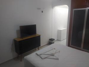 ein Schlafzimmer mit einem Bett und einem Fernseher auf einer Kommode in der Unterkunft Cavalinho Branco in Águas de Lindóia + 31 Fotos
