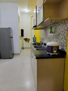 a kitchen with a sink and a counter top at Ivo Homestay Jogja in Gondowulung