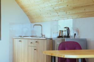 a kitchen with a sink and a wooden table at Cozy Cottages Kondidi in Kobuleti