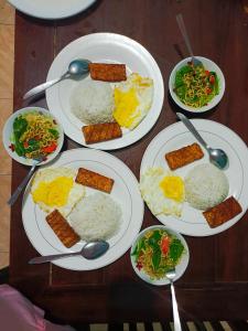 a table full of plates of food with rice at Backpackers Homestay in Labuan Bajo