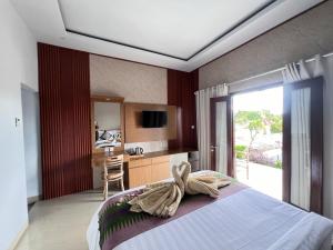 - une chambre avec un lit et une salle de bains avec une table dans l'établissement Lime Penida Cottages, à Nusa Penida
