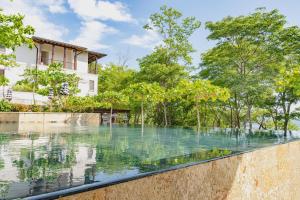 una piscina di fronte a una casa alberata di Paseo Divino At Las Catalinas a Playa Danta