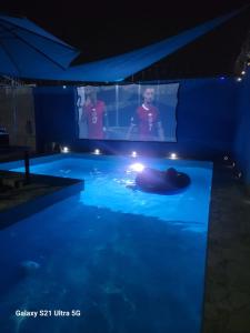 a swimming pool with a man in the water at night at Cabana Acunas House in Santa Marta