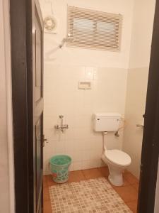 a small bathroom with a toilet and a window at Padamadan homestay in Cochin