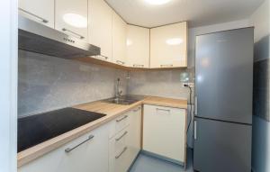 a kitchen with white cabinets and a stainless steel refrigerator at 2 Bedroom Awesome Apartment In Rtina in Rtina