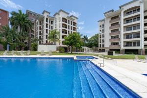 a swimming pool in front of some apartment buildings at Peninsula 25 in Tamarindo