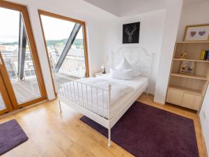 een witte slaapkamer met een bed en een balkon bij Ahrpartments Comfortable holiday residence in Bad Neuenahr-Ahrweiler