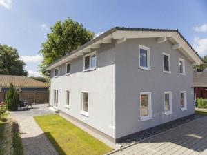 a white house with white windows and a yard at 1 - Eilrich Comfortable holiday residence in Thiessow