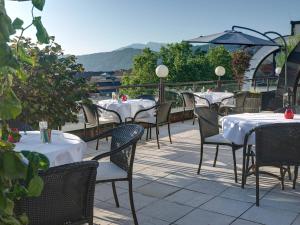 uma fila de mesas e cadeiras num pátio em Skycity Hotel Atrigon em Klagenfurt