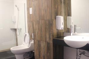 a bathroom with a toilet and a sink at My Studio Hotel Losari Makassar in Makassar