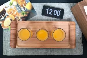 two glasses of orange juice sitting next to a clock at My Studio Hotel Losari Makassar in Makassar +21 photos
