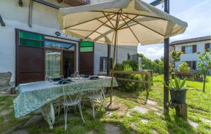 a table and chairs under an umbrella in a yard at Casa Ila in Casasco