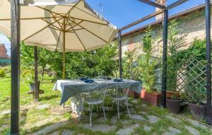 a table and an umbrella in a backyard at Casa Ila in Casasco +20 photos
