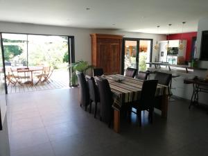 a kitchen and dining room with a table and chairs at Villa piscine chauffée,5ch ,climatisation, bar extérieur in Lacanau