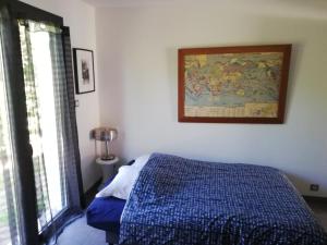 a bedroom with a bed and a painting on the wall at Villa piscine chauffée,5ch ,climatisation, bar extérieur in Lacanau +20 photos