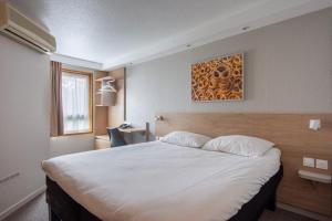 a bedroom with a large white bed in a room at Brit Hotel Mulhouse Centre in Mulhouse