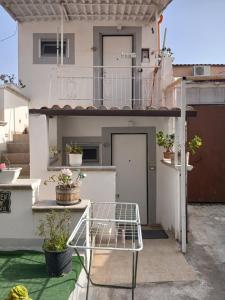 a small balcony with a table and potted plants at Garden green da VIRNA in Torre Annunziata
