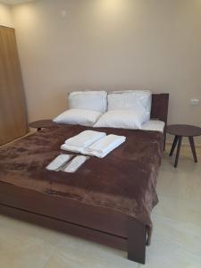 a bed with two towels on it with two tables at Argo rooms in Berehove +9 photos
