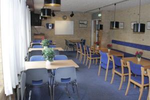 a dining room with tables and chairs and a whiteboard at Sæby Spektrum & Hostel in Sæby