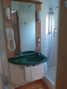 a bathroom with a green sink and a shower at Brit Hotel Mulhouse Centre in Mulhouse