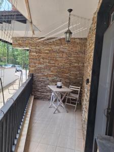 un patio con una mesa y una pared de ladrillo en Green Paradise apartman 105, en Primorsko