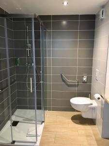 a bathroom with a glass shower and a toilet at Brit Hotel Martigues Nord in Martigues