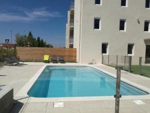 a swimming pool in front of a building at Brit Hotel Martigues Nord in Martigues +17 photos