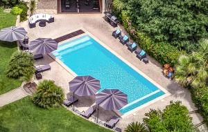 an overhead view of a swimming pool with chairs and umbrellas at Les Villas Au Palmier in Cannes-et-Clairan +38 photos