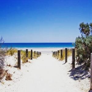 a path through the sand on a beach at Casa Luna Beachside Apartment in Henley Beach South