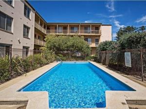 a swimming pool in front of a building at Casa Luna Beachside Apartment in Henley Beach South
